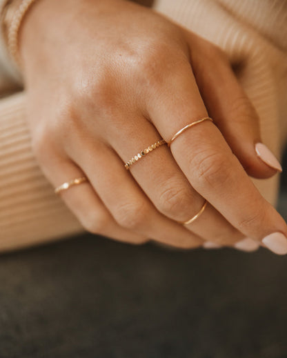 14k gold-filled dotted stacking ring worn on the hand — the Dottie by Saddle & Stone